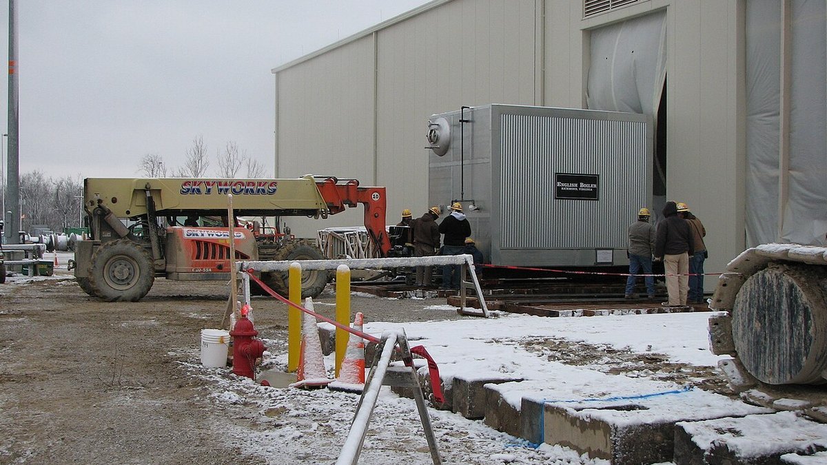 Industrial utility steam boiler room with high-pressure steam headers, valves, and water piping