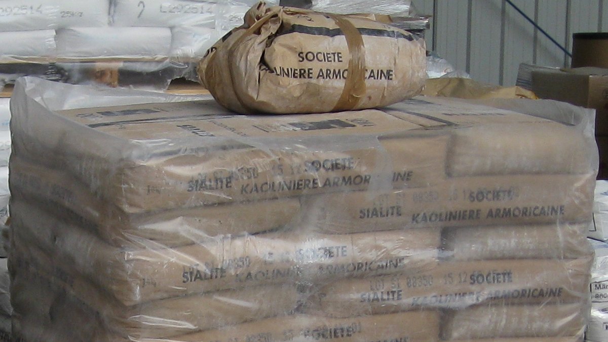 Palletized 25kg sacks of micronized mineral powder in an industrial chemical packaging warehouse