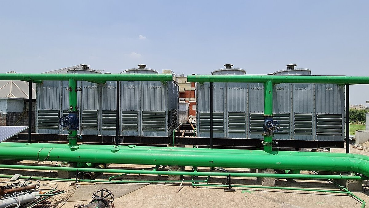 Rooftop induced-draft industrial cooling towers with large water distribution headers and valves