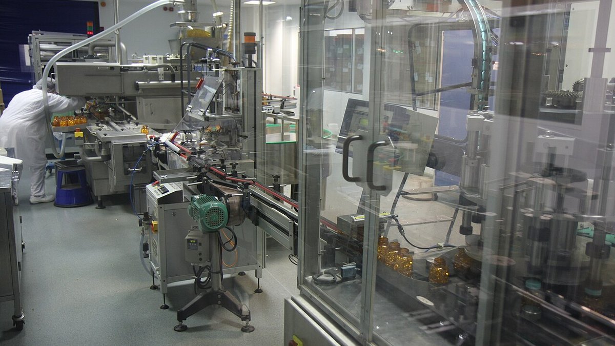 Automated pharmaceutical packaging line filling and sealing oral electrolyte containers in cleanroom