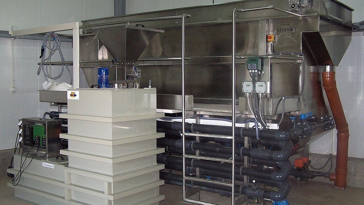 Industrial wastewater pH neutralization system showing reagent dosing pumps, static mixer, and reaction tank