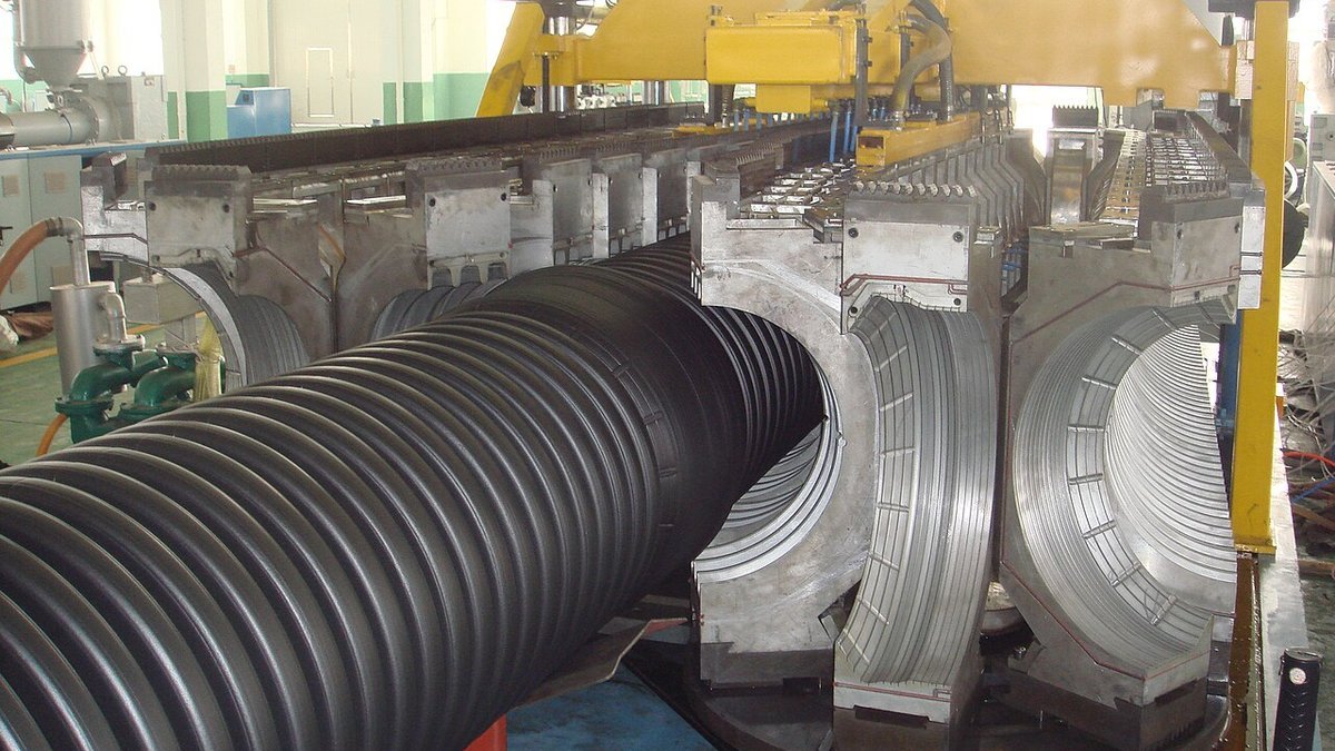 Heavy-duty plastic pipe corrugator extrusion die line producing corrugated drainage pipe in a plastics factory