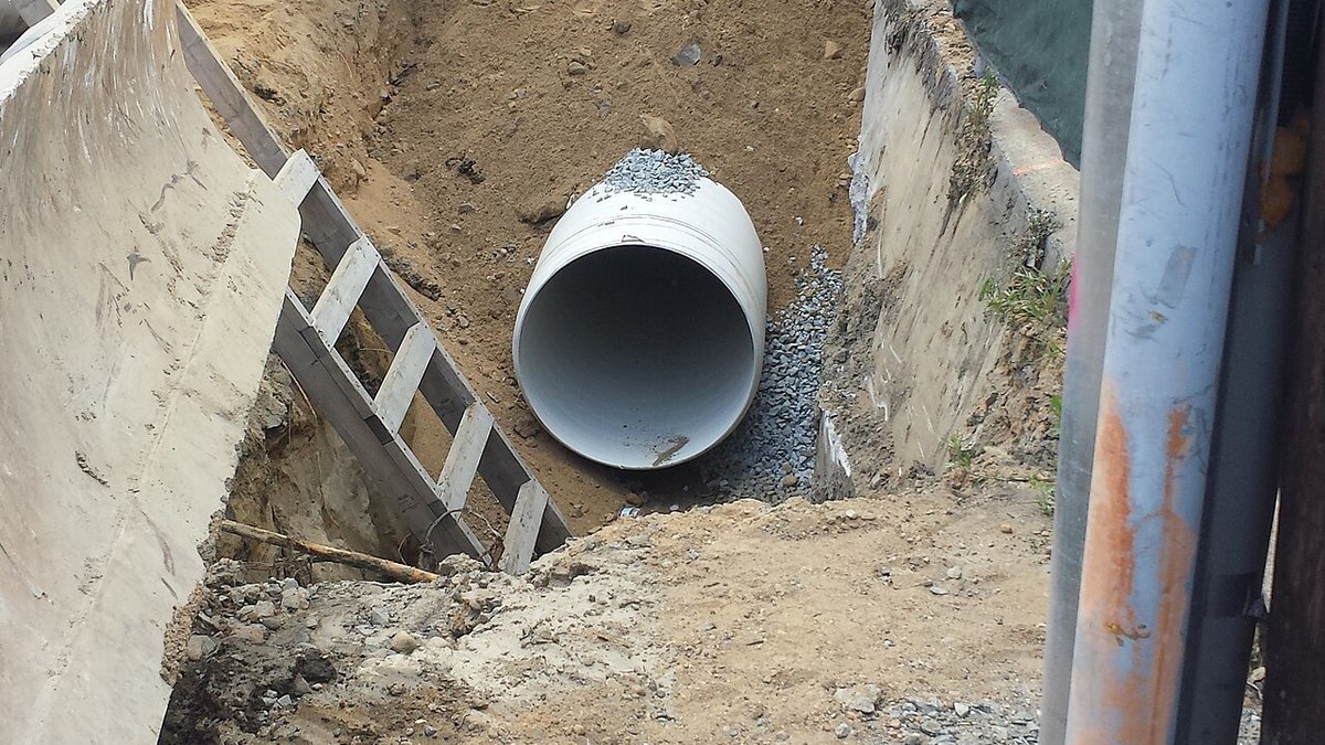 Large-diameter PVC drainage pipe installation showing welded bell joints and chemical solvent weld connections