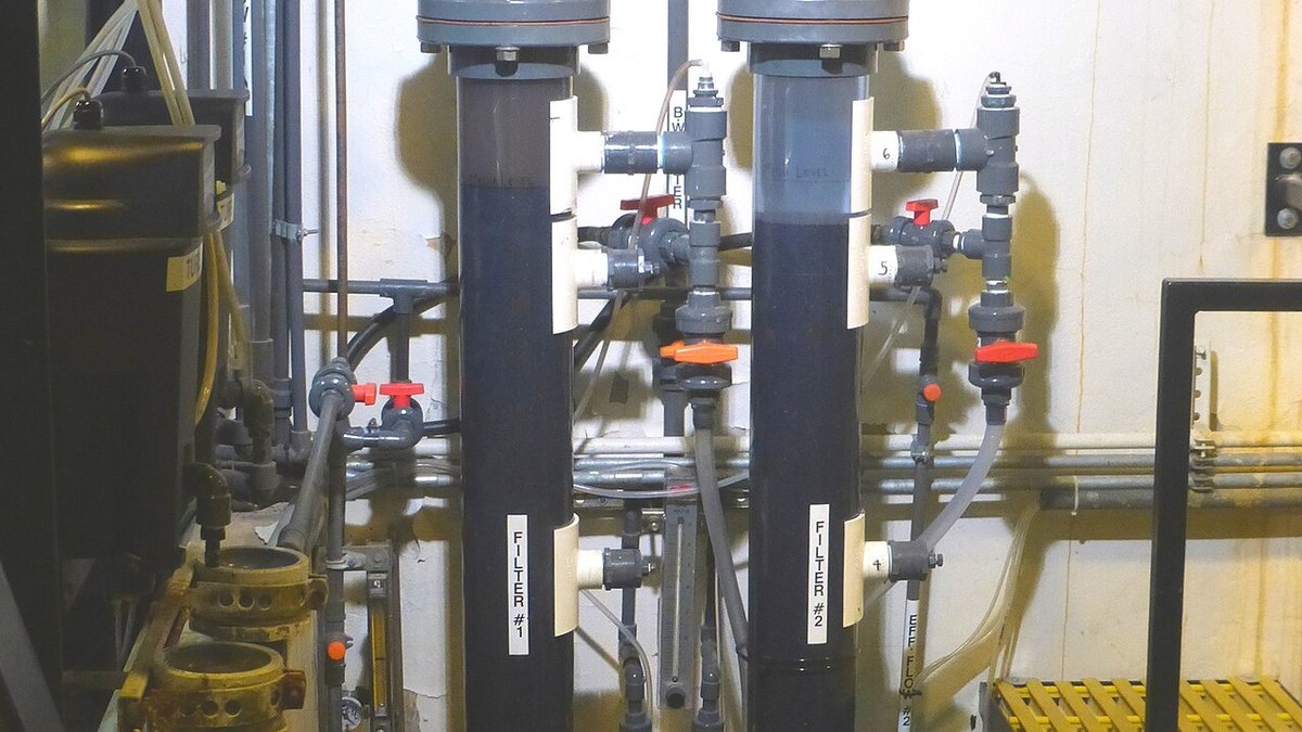 Twin industrial backwashing water column filters with pressure differential gauges and automated control valves